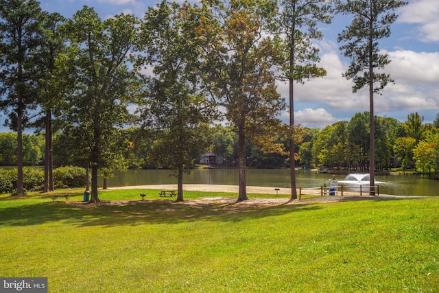 view of property's community with a yard and a water view