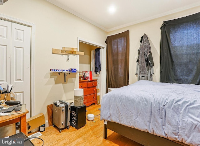 bedroom featuring ornamental molding, a closet, and hardwood / wood-style floors