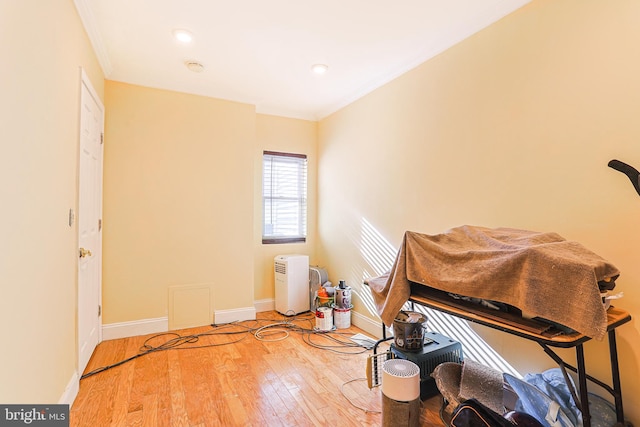 miscellaneous room with crown molding and wood-type flooring