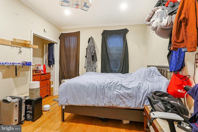 bedroom with ornamental molding and wood-type flooring