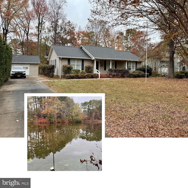 view of front of property with a garage, a water view, an outdoor structure, and a front lawn