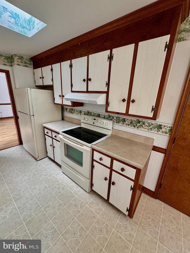 kitchen with white cabinets, white appliances, and a skylight