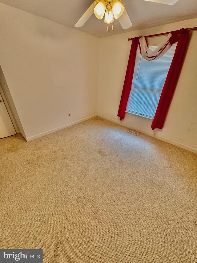 spare room featuring carpet and ceiling fan