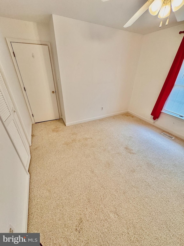 unfurnished room featuring ceiling fan and light colored carpet