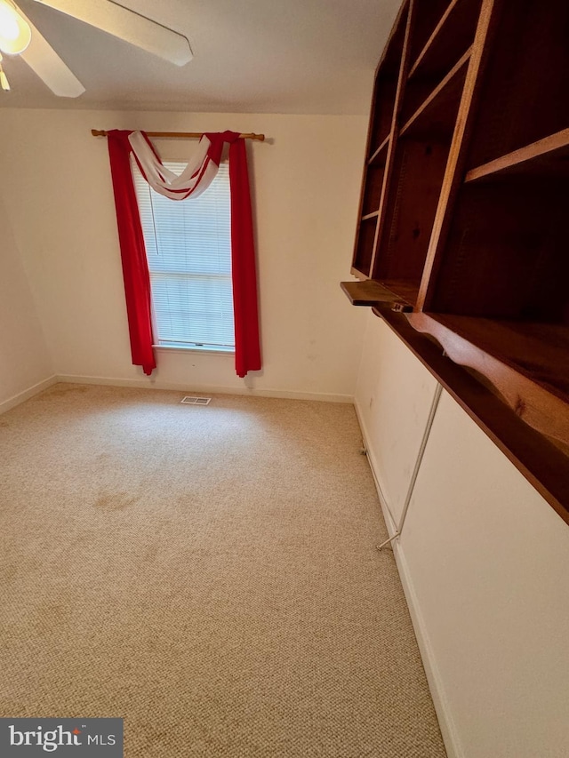 spare room featuring ceiling fan and carpet floors