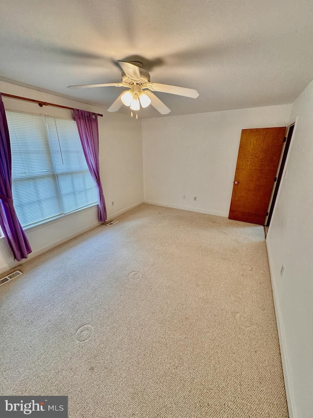 spare room with light carpet and ceiling fan