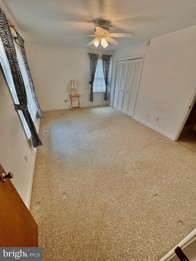 empty room with carpet flooring, a textured ceiling, and ceiling fan