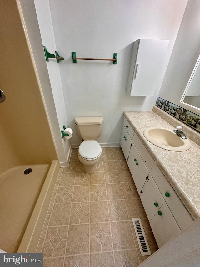 bathroom with vanity, toilet, and a shower