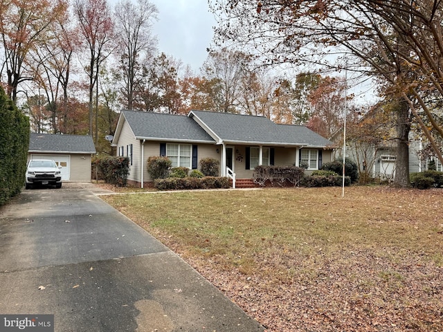 single story home featuring an outbuilding, a porch, a garage, and a front lawn