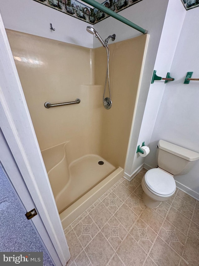 bathroom featuring tile patterned floors, toilet, and walk in shower