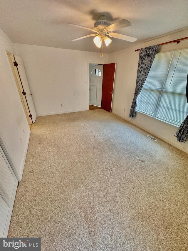 empty room featuring carpet and ceiling fan