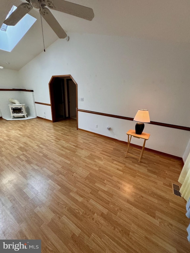 bonus room with light wood-type flooring, ceiling fan, and vaulted ceiling with skylight