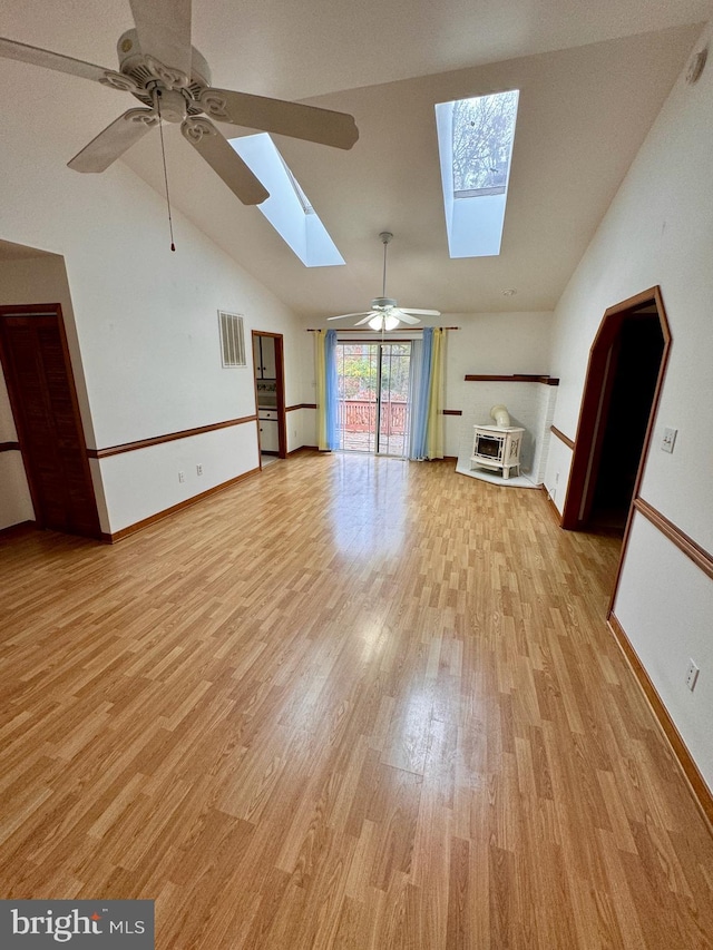 unfurnished living room with ceiling fan, light hardwood / wood-style floors, and lofted ceiling with skylight