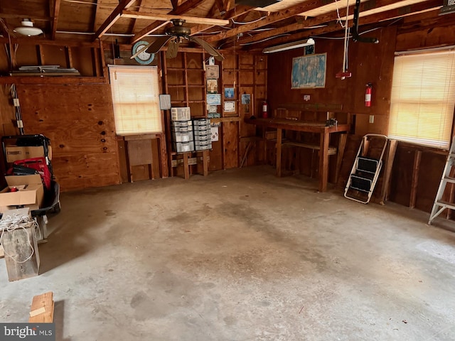 garage with a workshop area and wooden walls