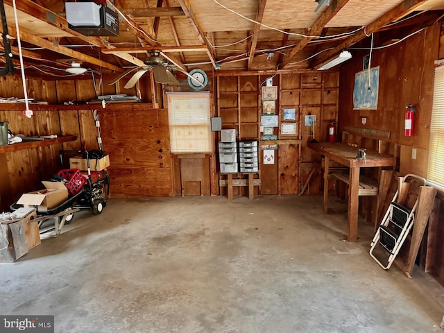 garage with a workshop area, wooden walls, and a garage door opener