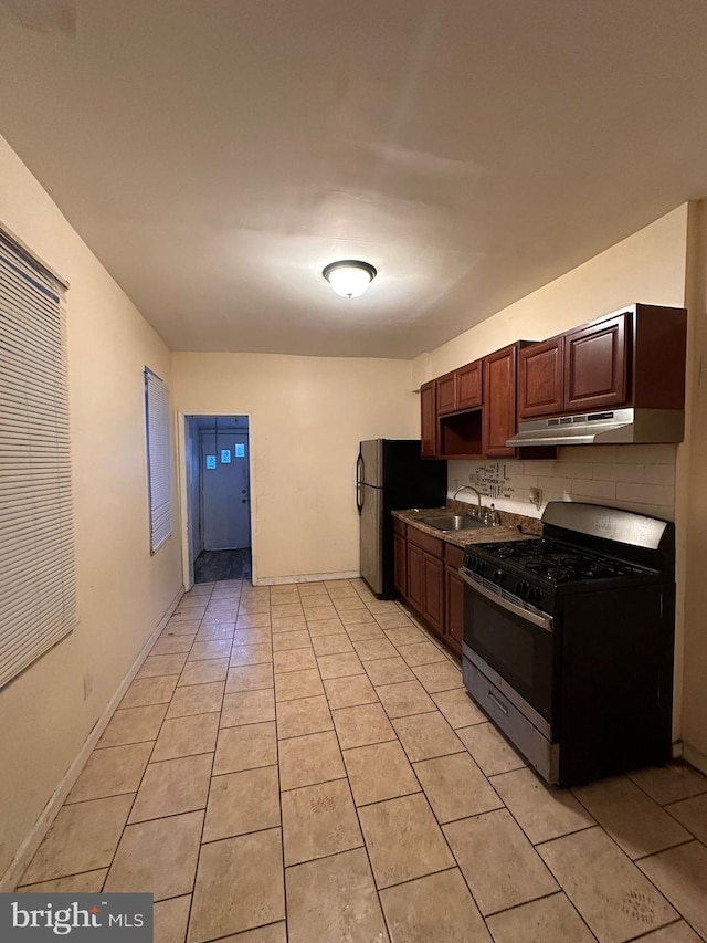 kitchen with decorative backsplash, sink, black gas range, stainless steel refrigerator, and light tile patterned flooring