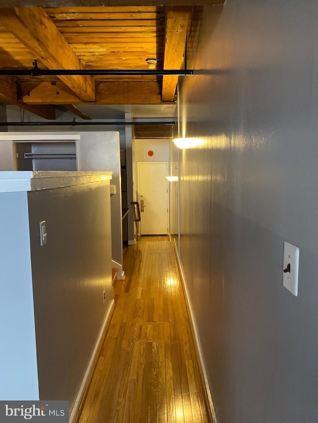 hall with beamed ceiling, hardwood / wood-style floors, and wood ceiling