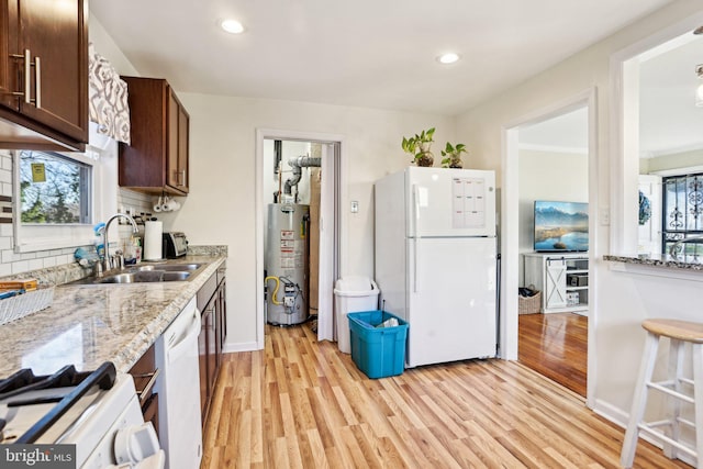 kitchen featuring sink, white appliances, plenty of natural light, and water heater