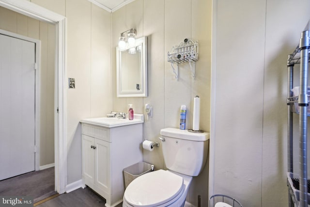 bathroom featuring vanity, toilet, and crown molding