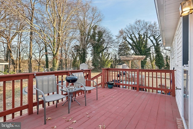 wooden terrace with a pergola and a shed