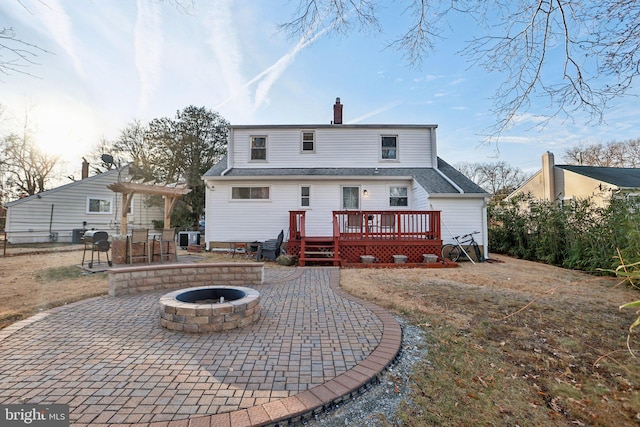 back of house with a wooden deck, a patio area, and a fire pit