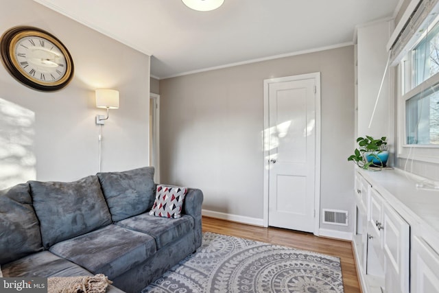 living room with ornamental molding and light wood-type flooring