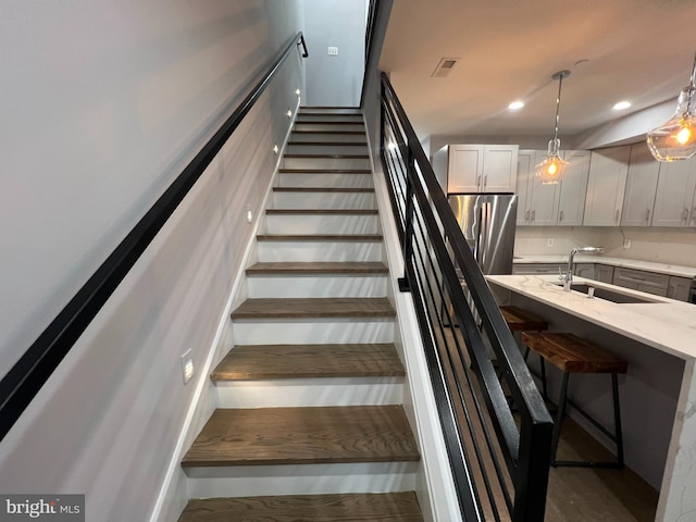 stairway featuring sink