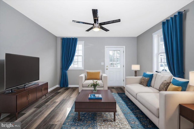 living room featuring ceiling fan and dark wood-type flooring