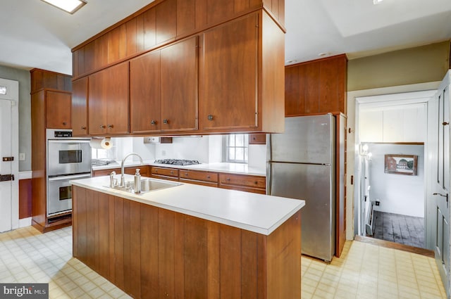 kitchen with sink, a kitchen island with sink, and appliances with stainless steel finishes