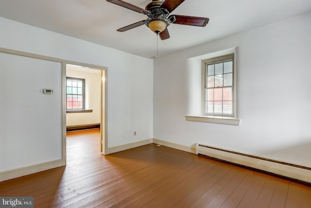 spare room with hardwood / wood-style floors, a baseboard radiator, and ceiling fan