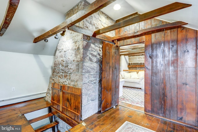 additional living space with lofted ceiling with beams, a baseboard radiator, and hardwood / wood-style flooring