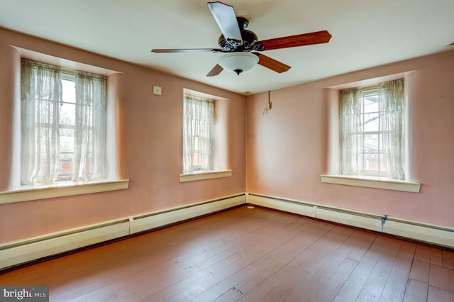 spare room with hardwood / wood-style flooring, a baseboard radiator, a wealth of natural light, and ceiling fan