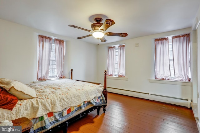 bedroom featuring hardwood / wood-style floors, ceiling fan, and a baseboard heating unit