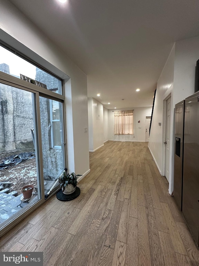 hallway with a wealth of natural light and light wood-type flooring