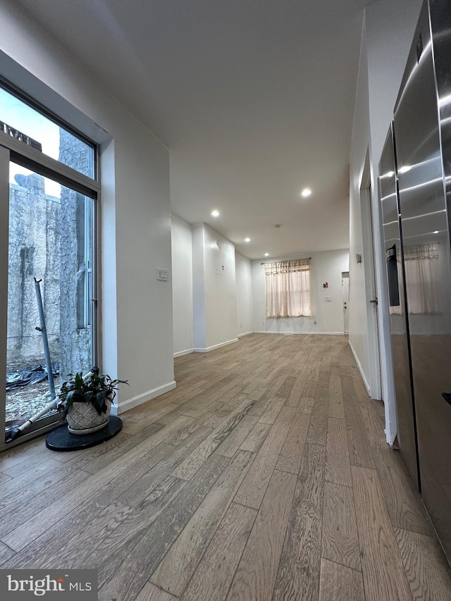 corridor featuring a wealth of natural light and hardwood / wood-style floors