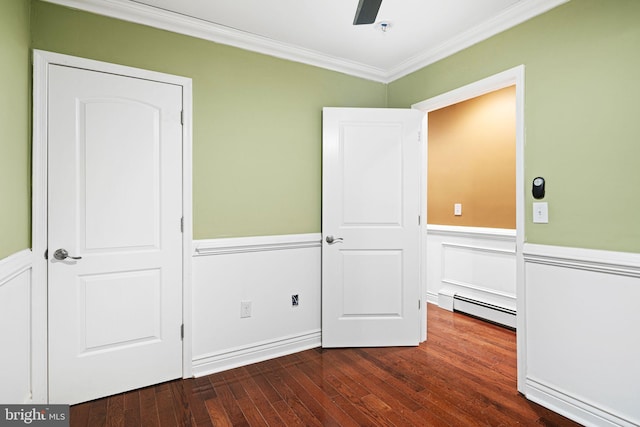 unfurnished bedroom featuring ceiling fan, ornamental molding, dark wood-type flooring, and a baseboard heating unit