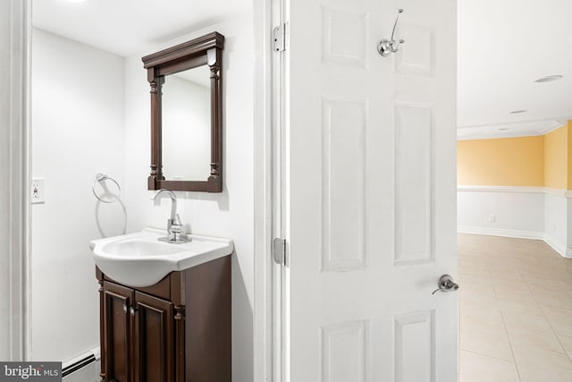 bathroom with tile patterned floors, vanity, ornamental molding, and baseboard heating