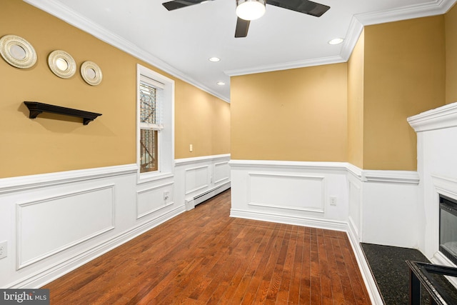 empty room with dark hardwood / wood-style flooring, baseboard heating, ornamental molding, and ceiling fan