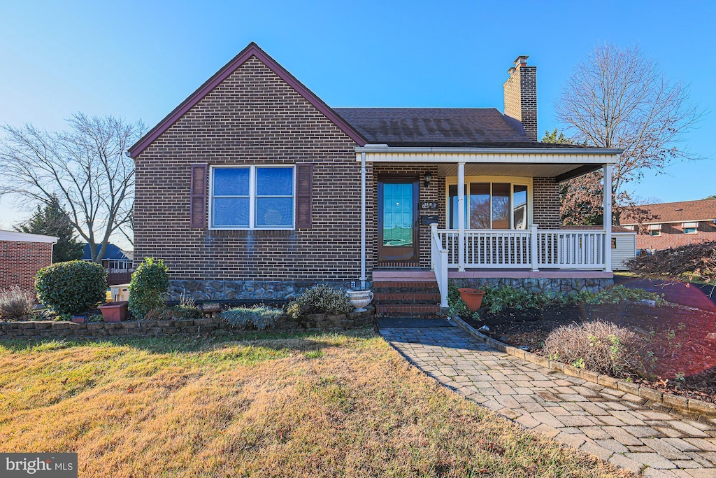 view of front facade featuring covered porch and a front yard