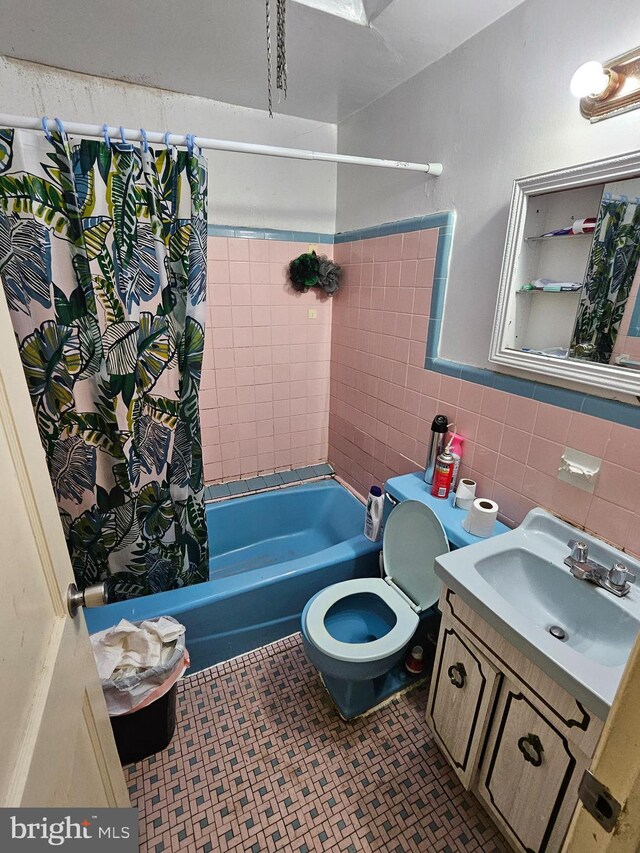 full bathroom with vanity, tile patterned floors, toilet, tile walls, and shower / tub combo