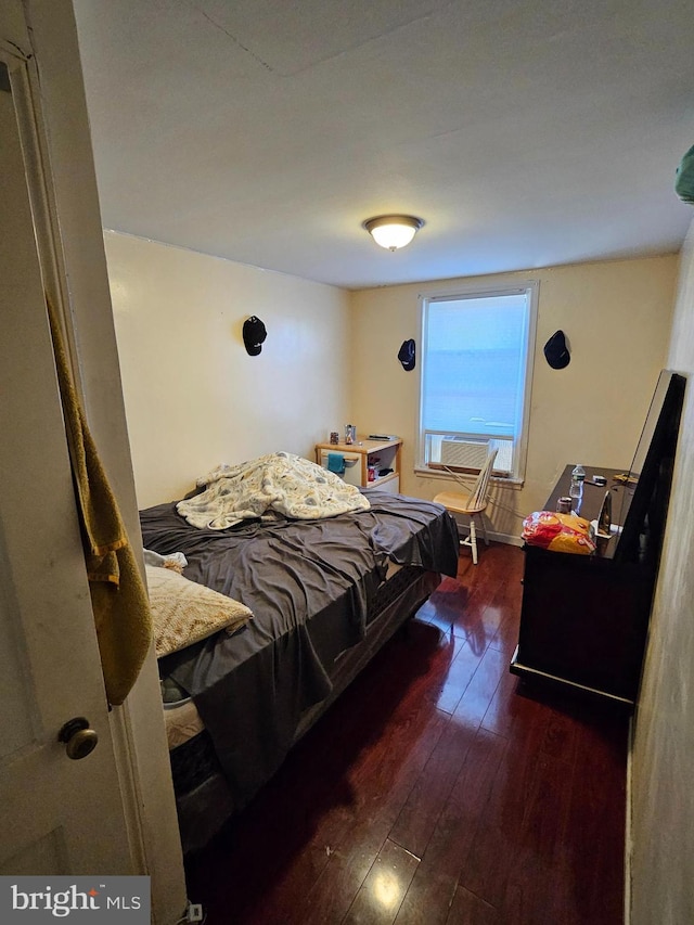 bedroom with dark hardwood / wood-style floors and cooling unit