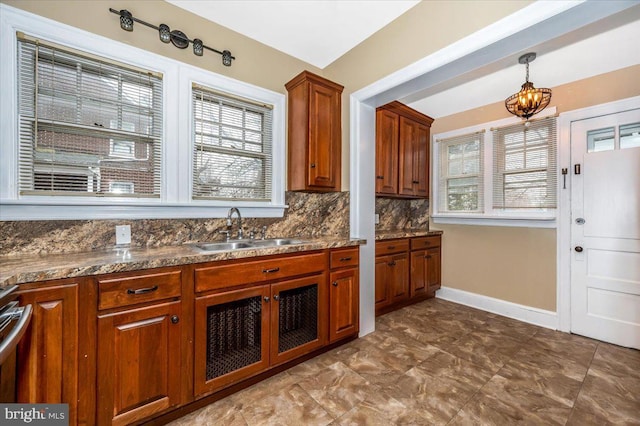 kitchen featuring backsplash, sink, and hanging light fixtures