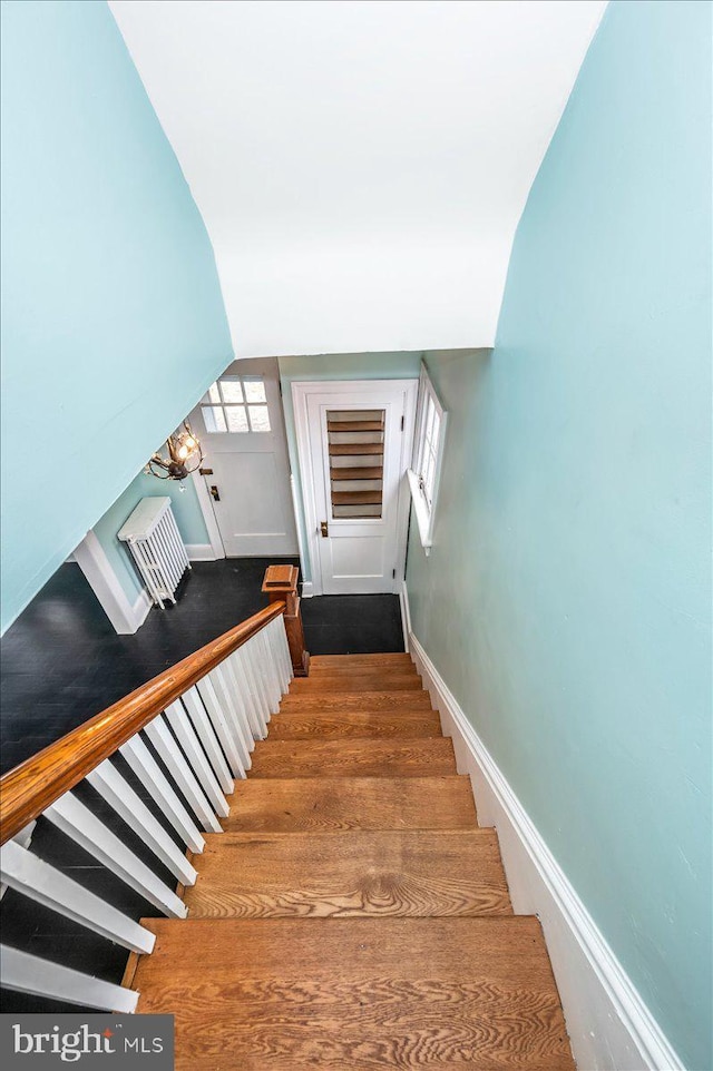 staircase featuring a wealth of natural light, a chandelier, and vaulted ceiling