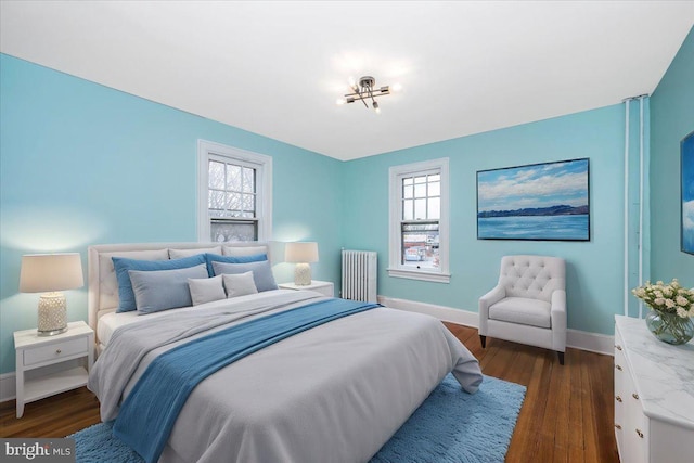 bedroom with radiator, multiple windows, a chandelier, and dark hardwood / wood-style floors