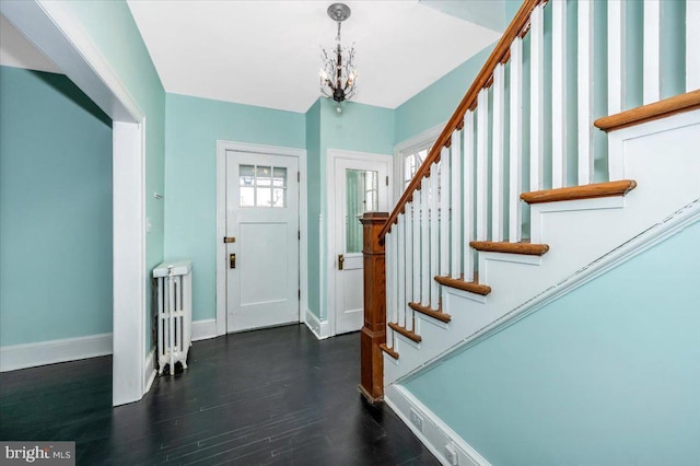 entrance foyer with a chandelier and dark hardwood / wood-style floors