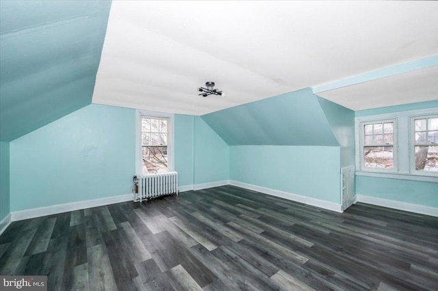 bonus room with radiator, dark hardwood / wood-style floors, and lofted ceiling