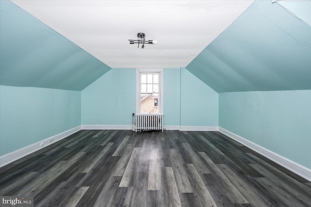 bonus room with lofted ceiling, radiator heating unit, and dark hardwood / wood-style floors