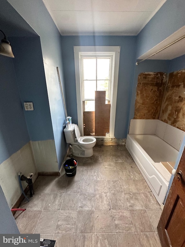 bathroom featuring a washtub and toilet