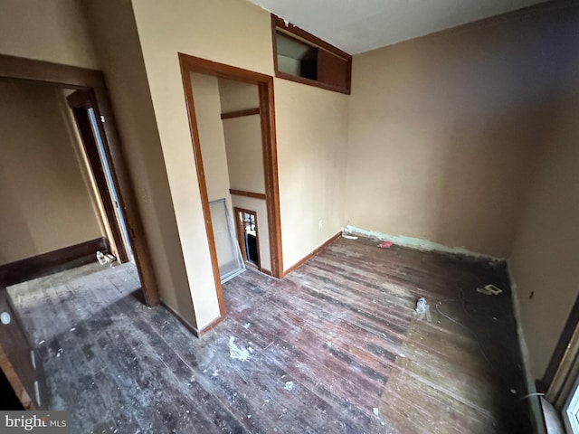 unfurnished bedroom featuring a closet and dark wood-type flooring