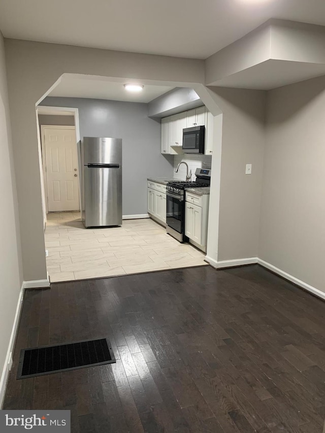 kitchen featuring white cabinets, stainless steel appliances, and light hardwood / wood-style floors